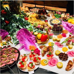 色とりどりの料理やフルーツや野菜がテーブルに並んでいる画像